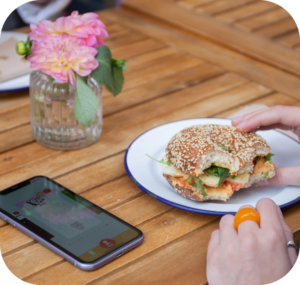 YeahBox,Würzburg,Bagel,Essen,Mittagspause,Hand,Handy,Shop,Lecker,Holztisch,Blume,Freunde,Partner,Stämpler,Kundinnen,Kunden,stämps,Stempelkarte,digitalstempeln,Bonuskarte,Nfc-Chip