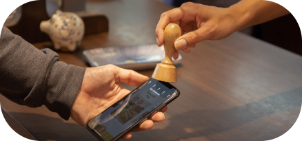 CafeManufaktur,Würzburg,Stempelvorgang,Digital,Hände,IPhone,Pfeile,HierStempeln,erhalten,Theke,Holz,Partner,Stämpler,Kundinnen,Kunden,stämps,Stempelkarte,digitalstempeln,Bonuskarte,Nfc-Chip